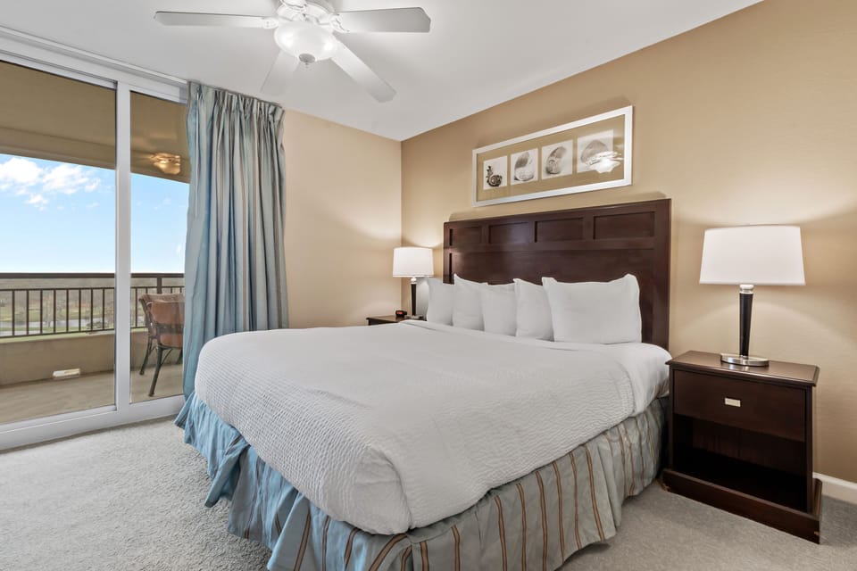 Unwind in your comfortable bedroom featuring a ceiling fan and private balcony with sliding doors that flood the space with natural light.