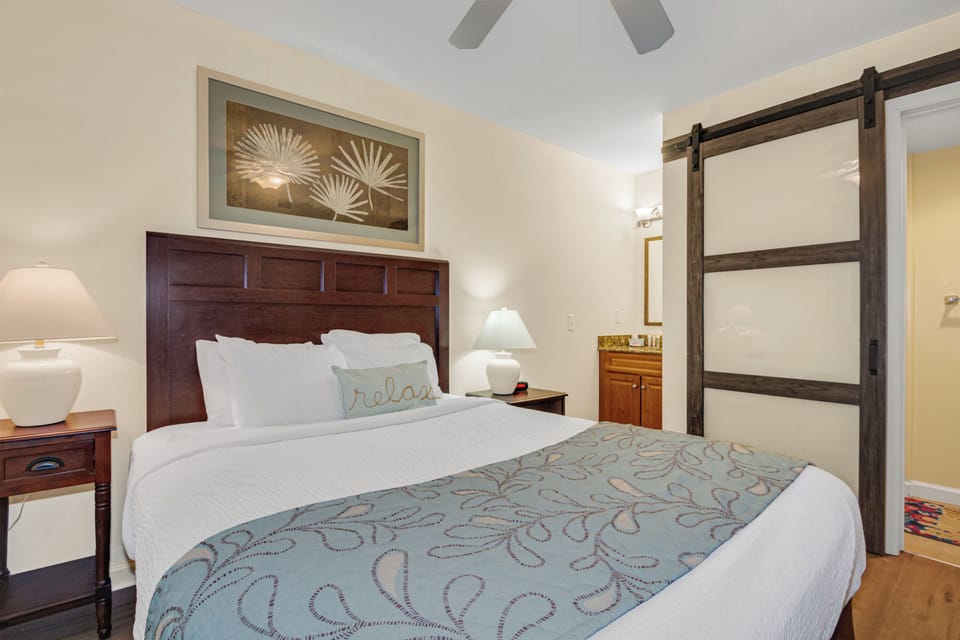 Unwind in your cozy bedroom featuring crisp linens, warm lighting, and charming barn-style doors that add rustic elegance to your peaceful retreat.