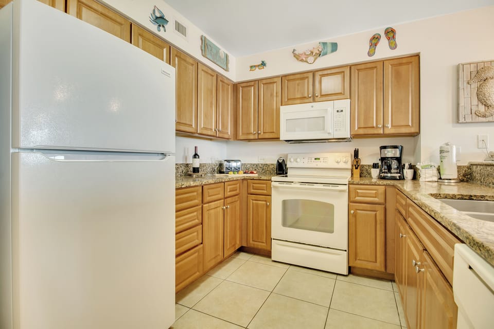 Your fully equipped kitchen awaits with warm wood cabinets, granite countertops, and everything you need to prepare delicious meals during your stay.