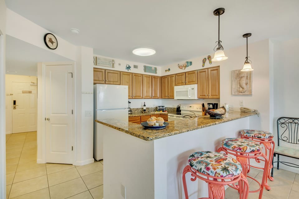 Your fully equipped kitchen features granite counters, modern appliances, and cheerful breakfast seating for convenient vacation dining.