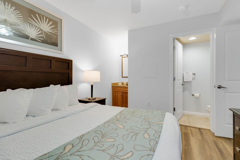 Drift into peaceful sleep in your serene bedroom, where crisp linens and elegant tropical touches create the perfect sanctuary for rest.