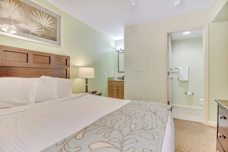 Unwind in your serene bedroom featuring crisp linens and warm wood accents, with your private bathroom just steps away.