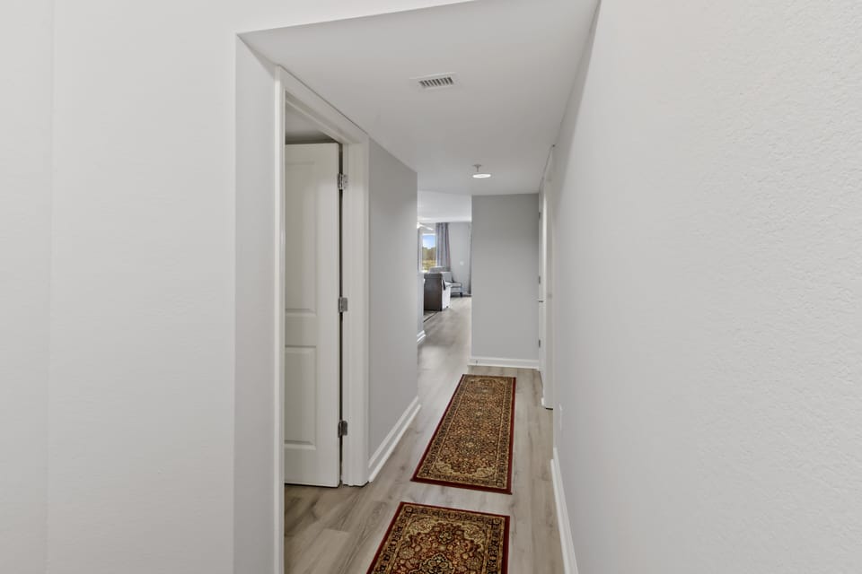 Step into your bright, welcoming hallway where elegant runners guide you to cozy rooms ahead.