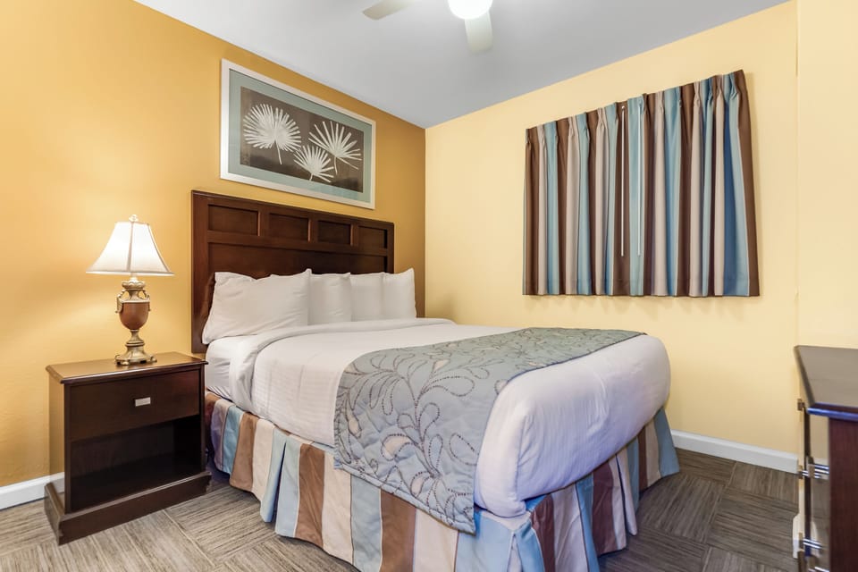 Sink into crisp white linens and let the warm amber walls embrace you in this cozy bedroom retreat.