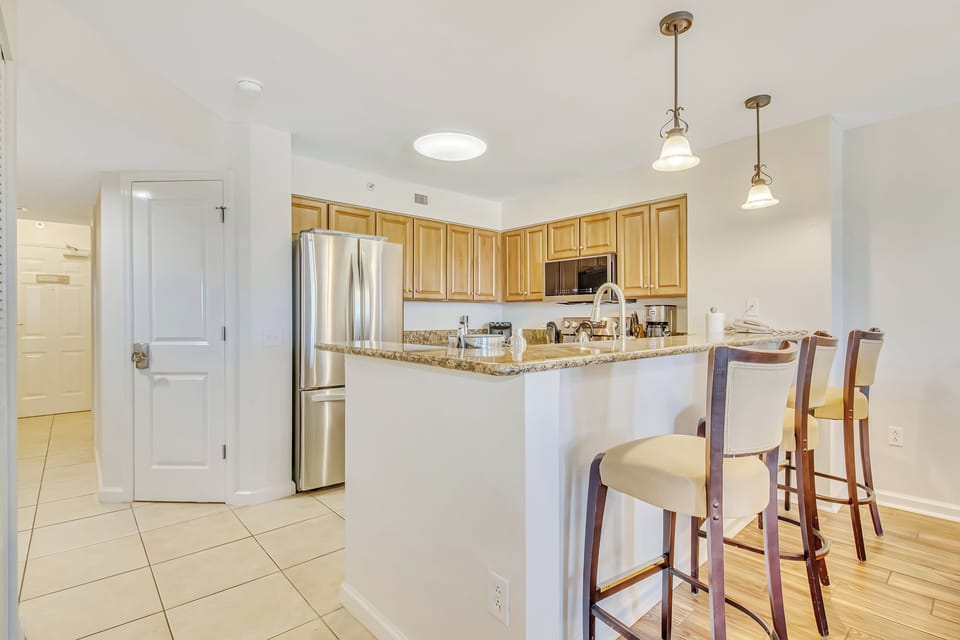 Your fully equipped kitchen features granite countertops, stainless steel appliances, and a breakfast bar where you can enjoy morning coffee.