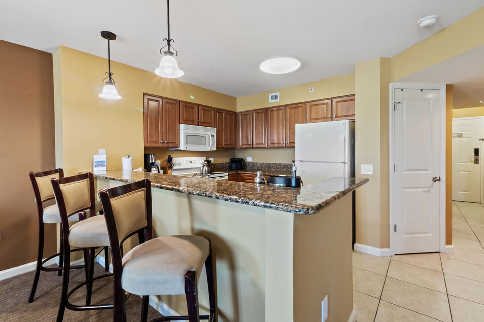Your fully equipped kitchen features granite counters, stainless appliances, and a breakfast bar where you can enjoy morning coffee together.