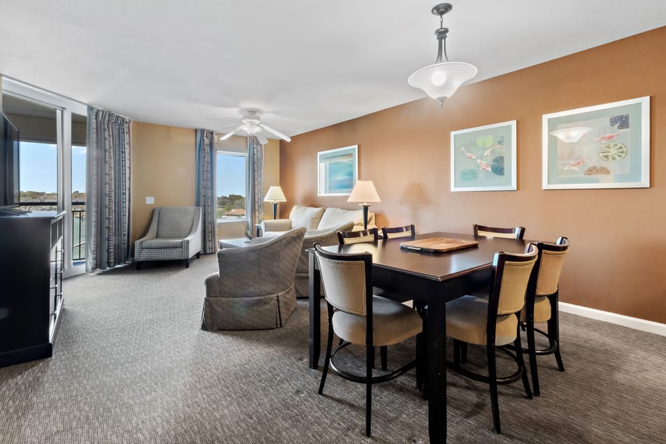 Your spacious dining area features elegant seating for six, perfect for family meals while enjoying natural light from large windows.