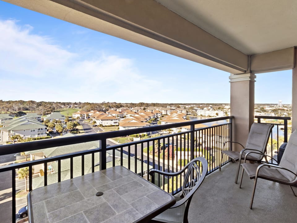 Spacious covered balcony offers comfortable seating with sweeping views of the surrounding residential community and natural landscape beyond.