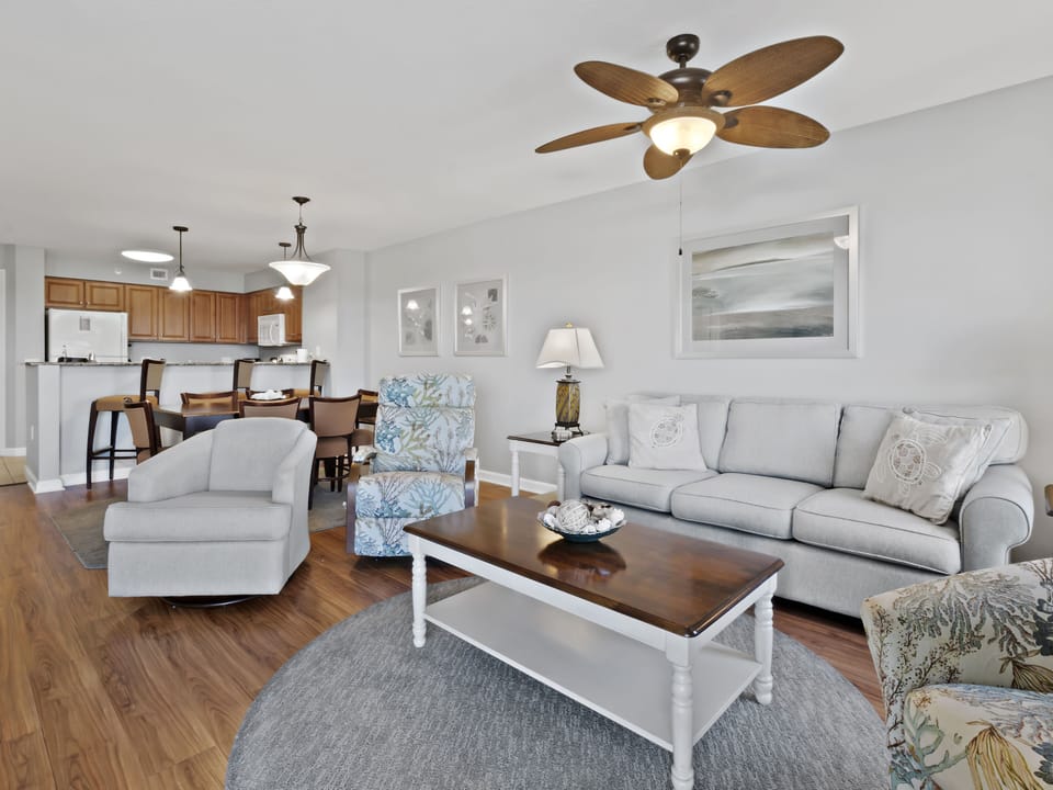 Unwind in your spacious living room with plush seating, coastal décor, and an open-concept flow to the kitchen—perfect for relaxing together.