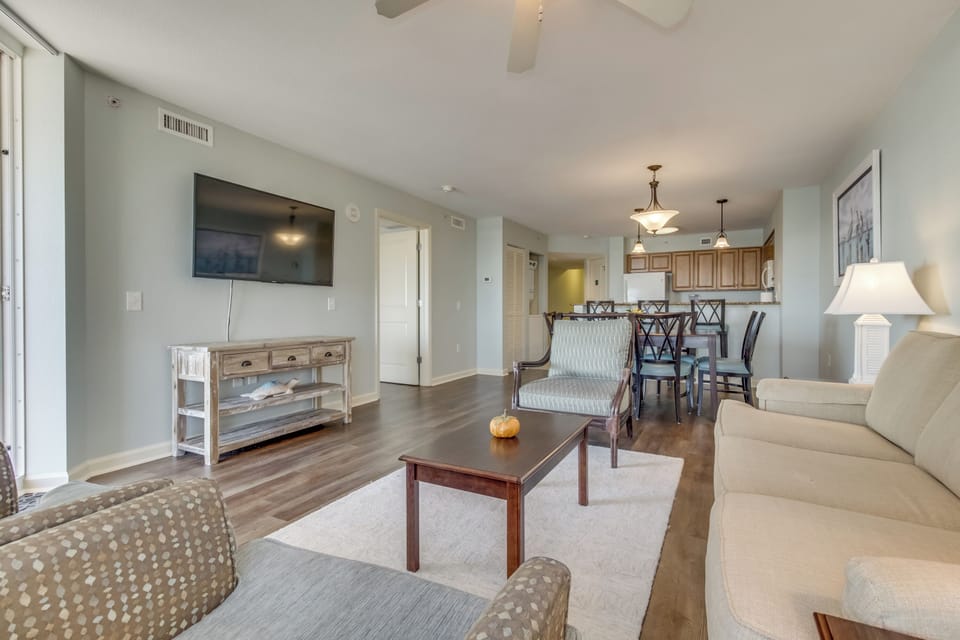 Relax in your elegant open-concept living space with coastal colors, comfortable seating, and modern amenities for memorable vacation moments.