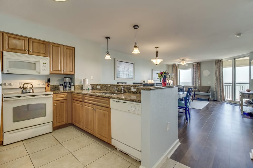 Your spacious kitchen flows seamlessly into the living area, perfect for cooking meals while enjoying ocean views through floor-to-ceiling windows.