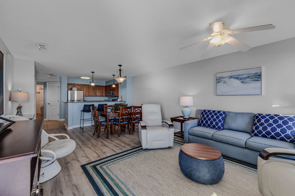 Relax in your spacious open-plan retreat with coastal blue accents, comfortable seating, and a fully equipped kitchen perfect for home-cooked meals.