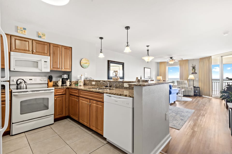 Your spacious kitchen flows seamlessly into the living area, perfect for cooking while enjoying conversations and ocean views through floor-to-ceiling windows.
