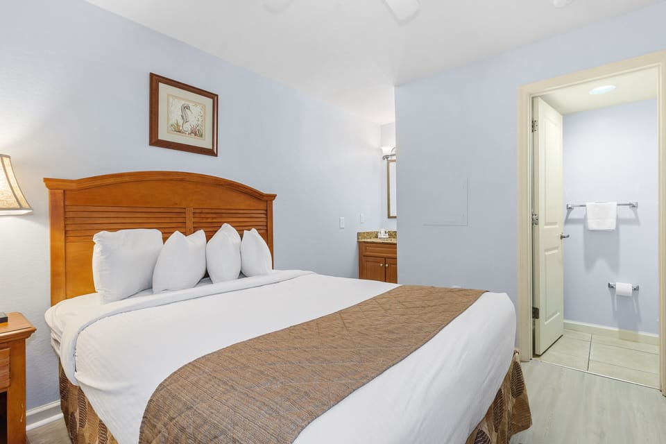 Rest peacefully in your comfortable bedroom with plush white bedding and warm wood furnishings, plus your own private bathroom just steps away.