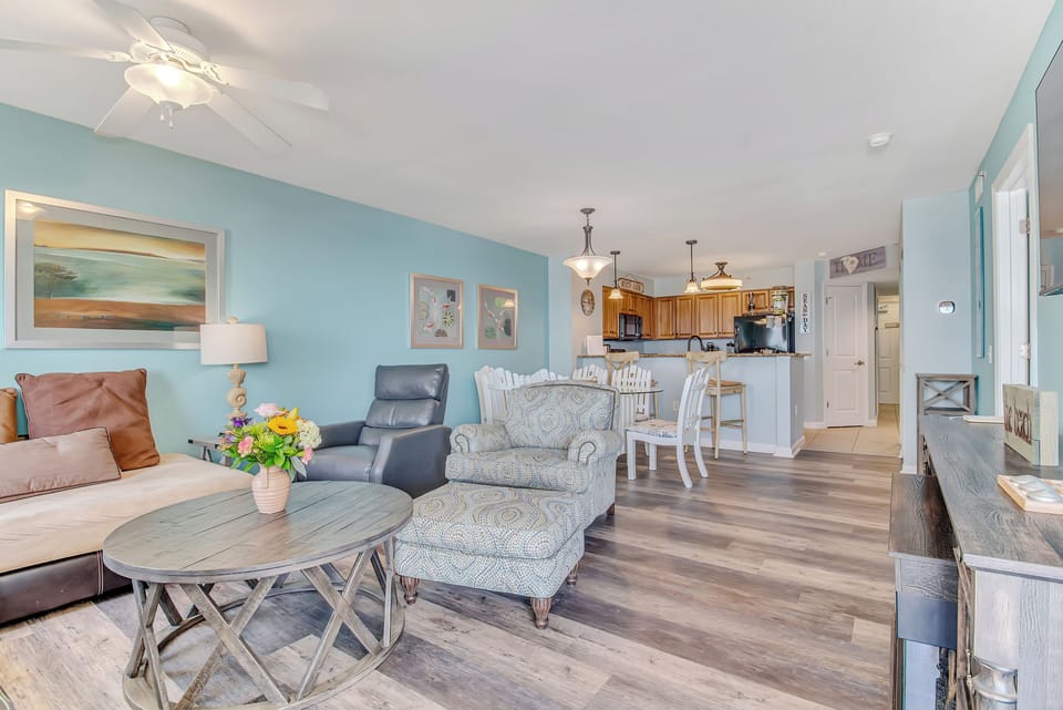 Relax in your open-concept retreat with coastal charm, where soft blue walls and comfortable seating create the perfect space to unwind.