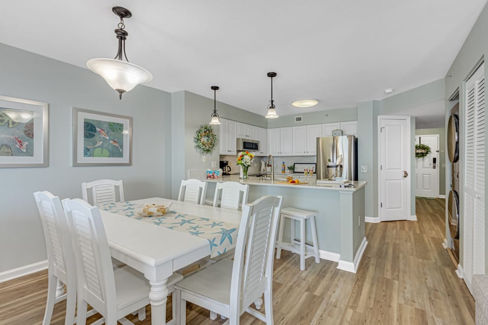 Your coastal-inspired dining space flows seamlessly into a fully equipped kitchen, perfect for memorable meals together.