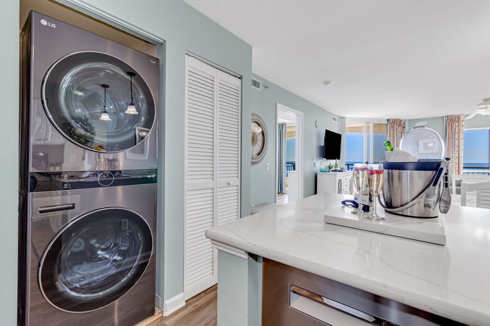 Your private laundry room features modern stacked washer and dryer units with plenty of counter space for folding.