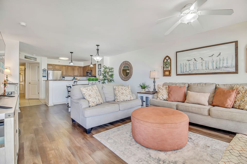 Sink into plush sofas in your open living space, where coastal decor and warm wood floors create the perfect setting for relaxation.