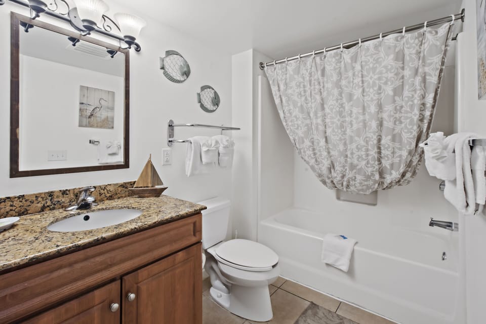 Refresh in your nautical-themed bathroom with granite countertops, tub-shower combo, and coastal touches that make every morning feel like a seaside retreat.