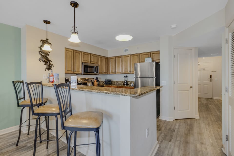 Your fully equipped kitchen awaits with granite counters, stainless appliances, and breakfast bar seating for casual dining.