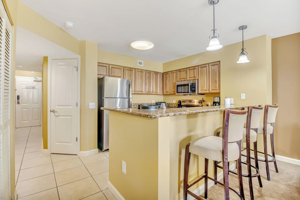 Your spacious kitchen features granite counters, stainless appliances, and a breakfast bar perfect for morning coffee.