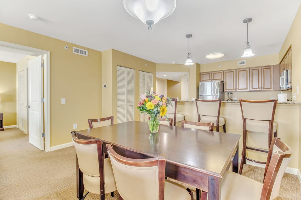 Gather around this spacious dining table where fresh flowers create the perfect setting for your memorable meals together.
