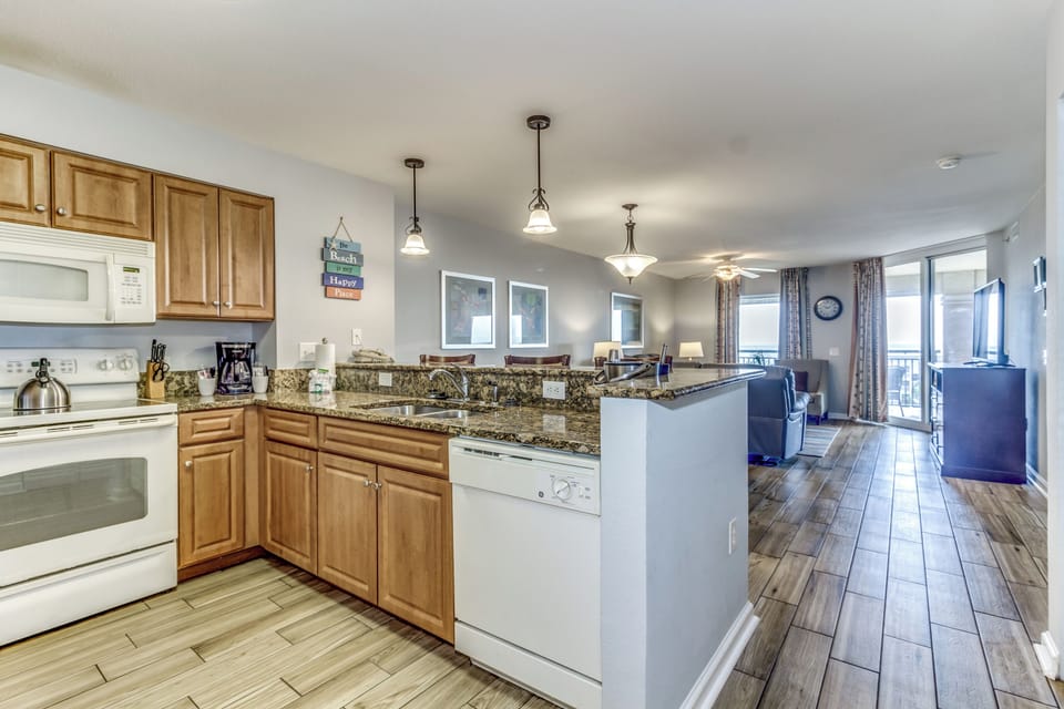Cook your favorite meals in this fully equipped kitchen with granite counters, modern appliances, and open layout flowing into the living space.