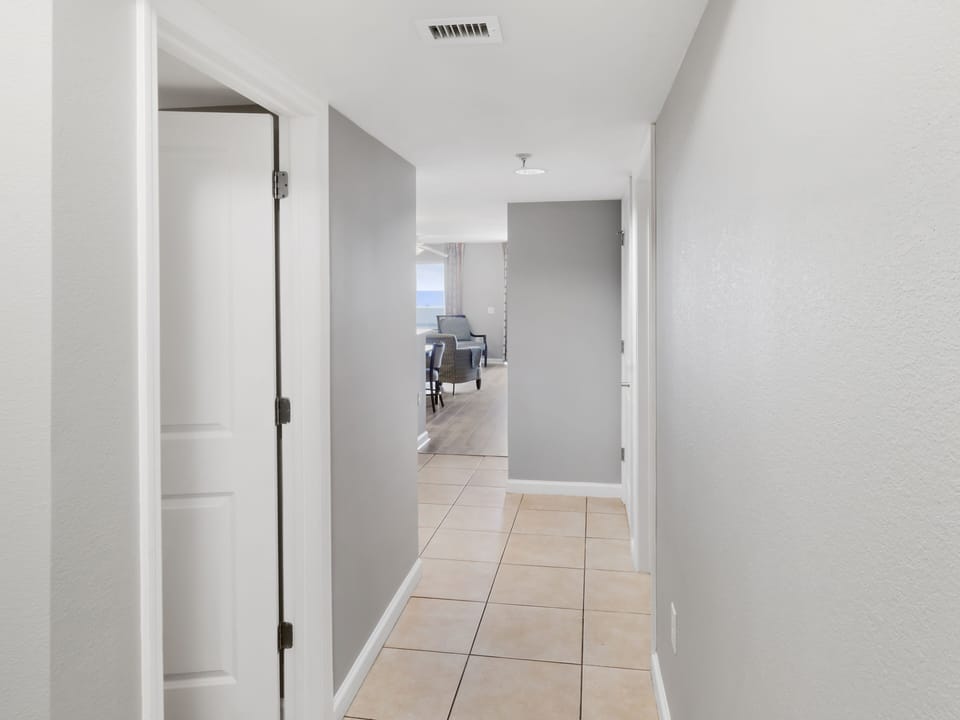 Step into your bright, modern hallway with clean lines and tile floors leading to the comfortable living space beyond.