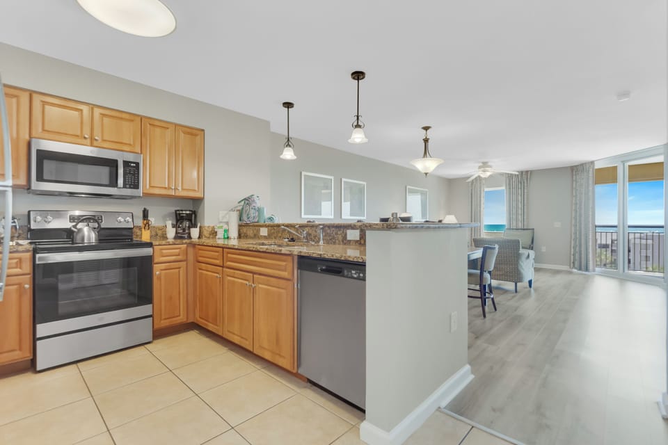 Your fully equipped kitchen opens to a bright living area with stunning ocean views through floor-to-ceiling windows.