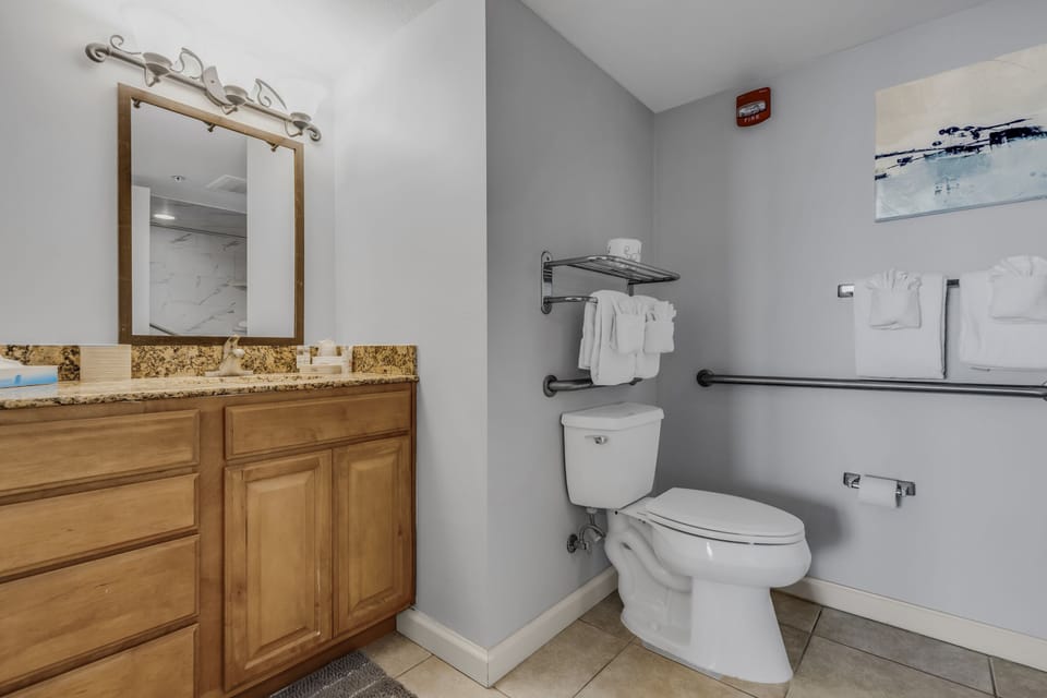 Your accessible bathroom features a spacious vanity with granite countertops, fresh towels, and thoughtful grab bars for comfort and safety.