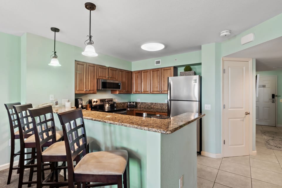 Cook your favorite meals in this spacious kitchen featuring granite countertops, modern appliances, and a breakfast bar perfect for casual dining.