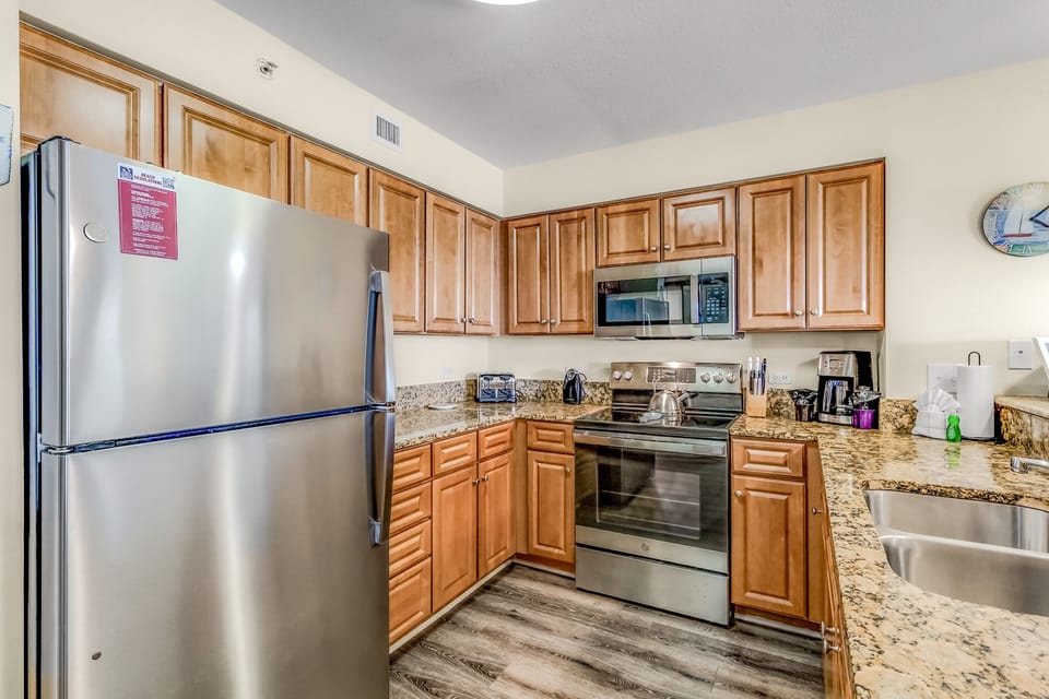 Your fully equipped kitchen features granite countertops, stainless steel appliances, and ample cabinet storage for preparing memorable meals together.