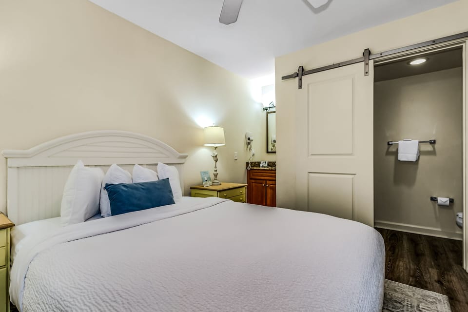 Settle into your beautifully appointed bedroom featuring crisp linens, modern amenities, and a stylish sliding barn door leading to your private bathroom.