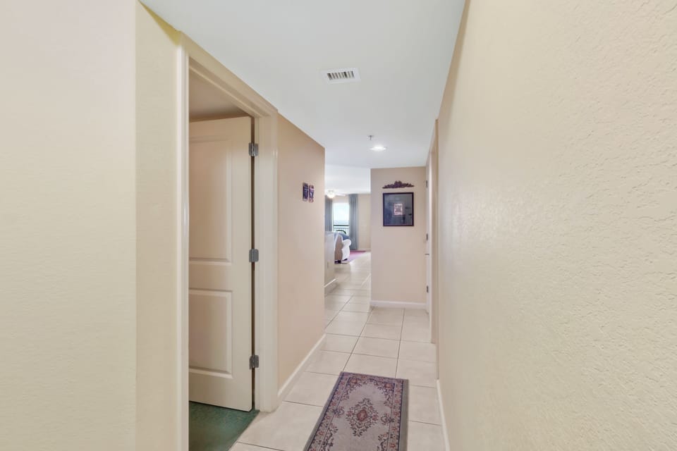 Your private hallway connects all living spaces with elegant tile floors and thoughtful artwork creating a welcoming home atmosphere.