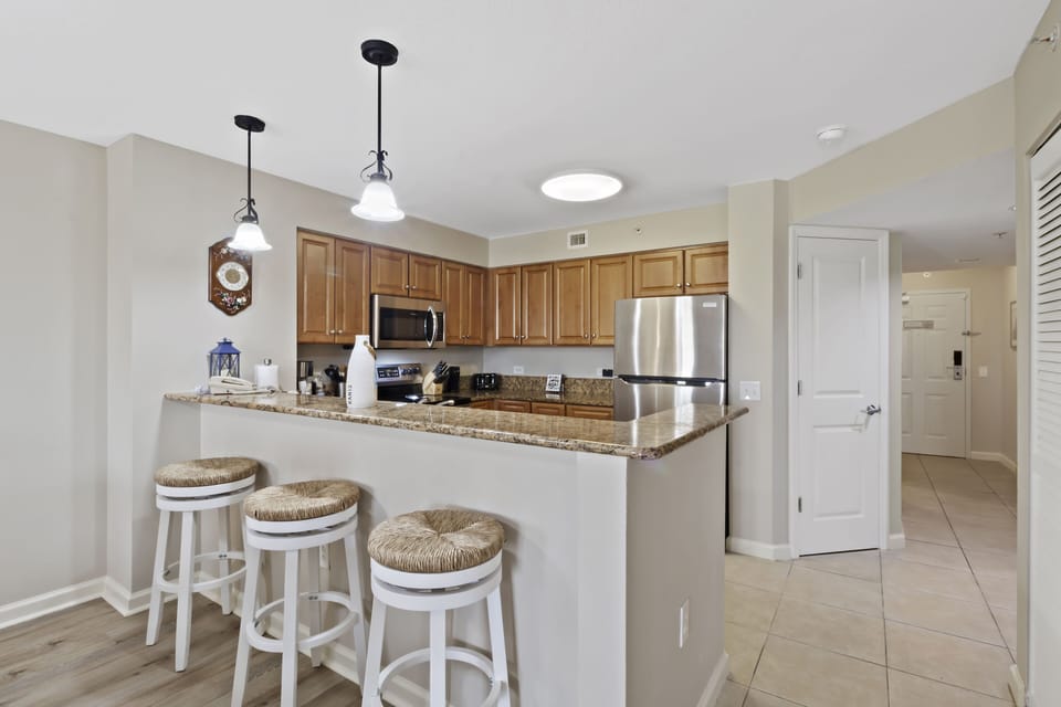 Your fully equipped kitchen features granite counters, stainless appliances, and a breakfast bar perfect for morning coffee or casual meals.