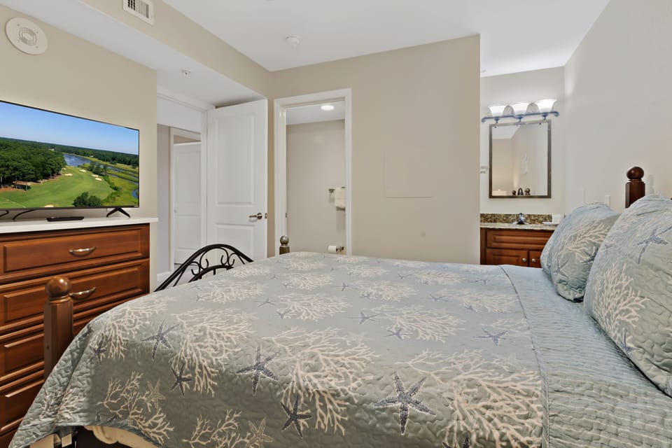 Unwind in your serene bedroom with plush bedding, flat-screen TV, and elegant furnishings designed for your ultimate comfort and relaxation.