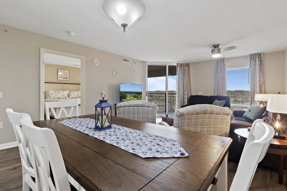 Gather around your spacious dining table while enjoying scenic views through floor-to-ceiling windows in this bright, open-concept living space.