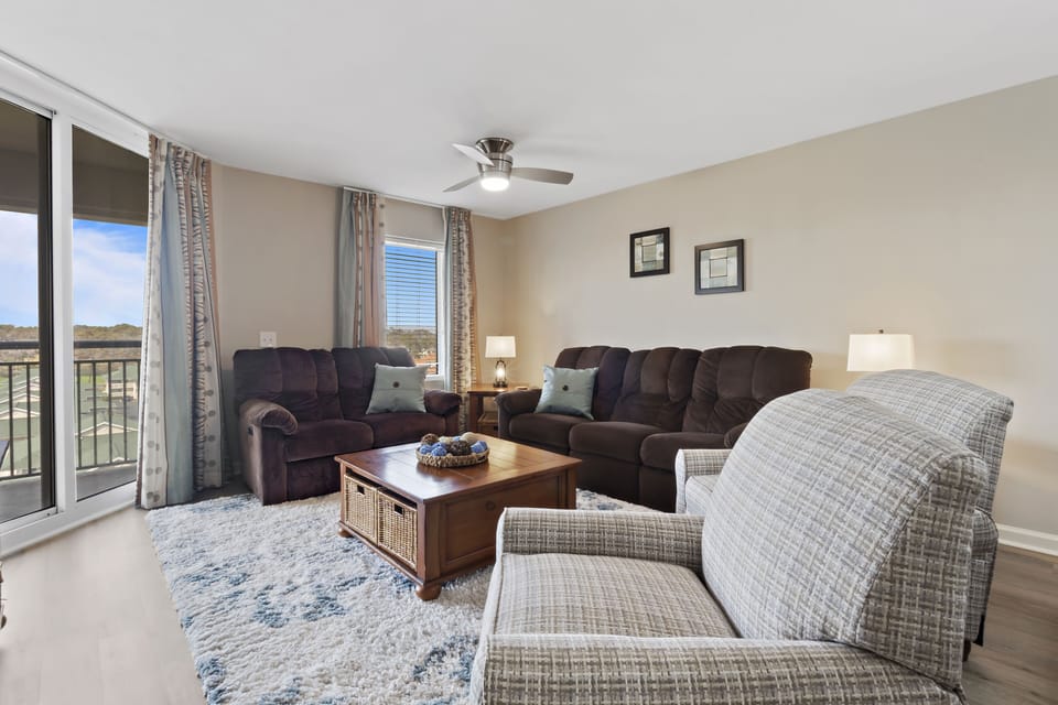 Unwind in your spacious living room with plush seating and natural light streaming through sliding doors to your private balcony.