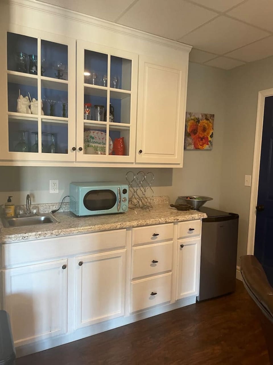 Basement Bonus Room Kitchenette with Wet Bar, Mini Fridge, Microwave, and Drinkware Enjoy the convenience of a fully equipped kitchenette featuring a wet bar, mini fridge, microwave, and a selection of plastic cups and glasses—perfect for refreshments and