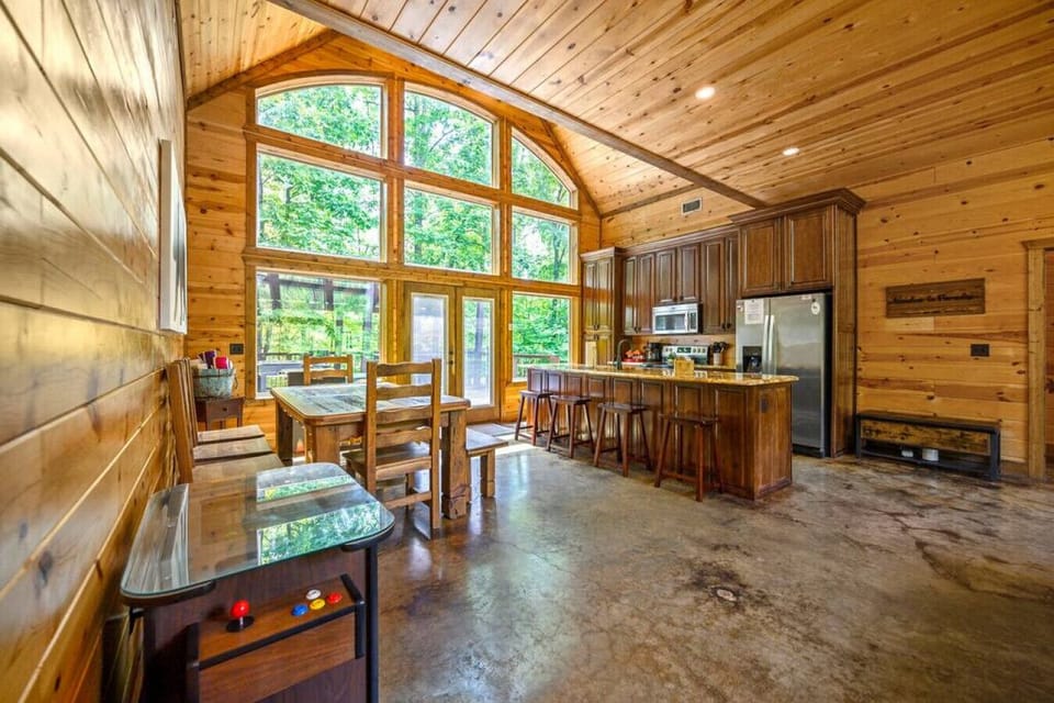 Bask in the warmth of the fireplace`s glow as sunlight streams through the high windows, casting a cozy spell on this cabin`s inviting open kitchen.
