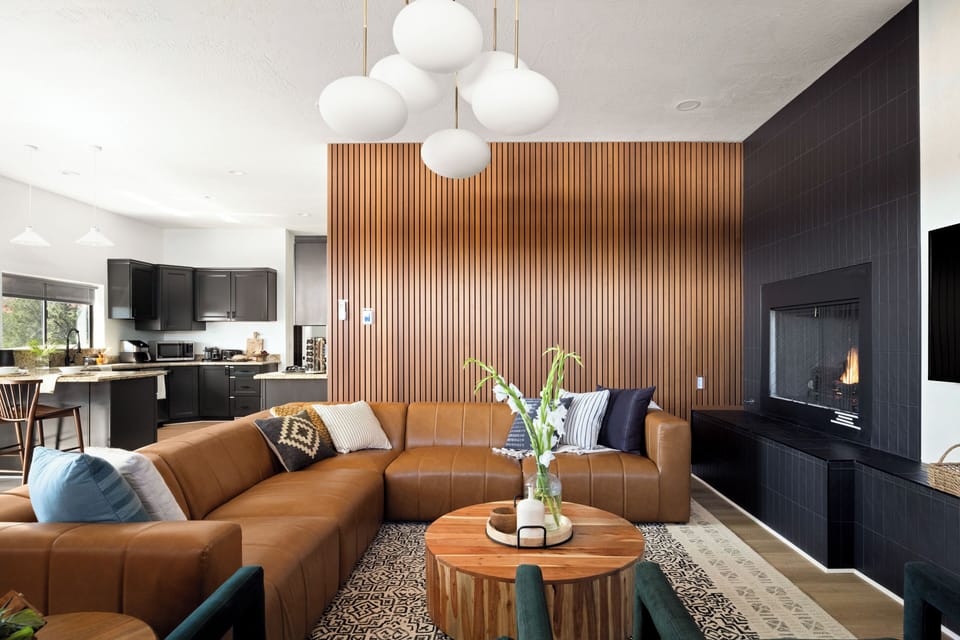 Chic and cozy atmosphere featuring leather furnishings, a TV, and a fireplace.