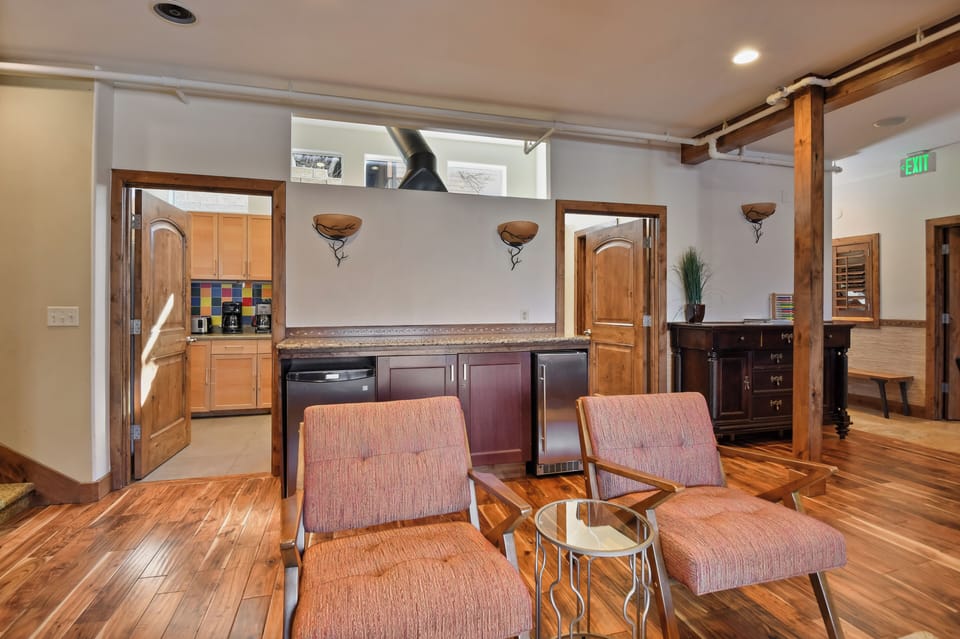 Relax in this stylish open-plan living space with rich hardwood floors, where modern comfort meets rustic charm through exposed beams and thoughtful design.
