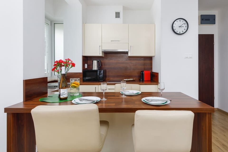 A kitchen featuring modern appliances, wooden cabinets, and a backsplash with geometric patterns.