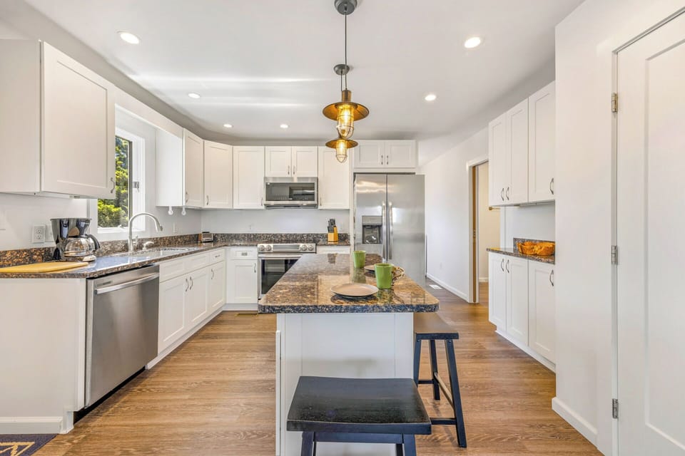 Step into your spacious gourmet kitchen, where crisp white cabinetry and gleaming granite countertops invite you to whip up memorable meals together beneath warm pendant lighting.