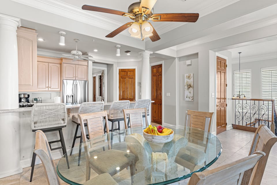 Gather around your elegant glass dining table beneath charming exposed beams, with the gourmet kitchen just steps away for easy entertaining.