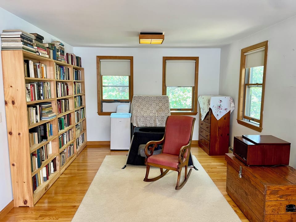 Master bedroom: mobile cot, books, 12,000 BTU window AC, shades