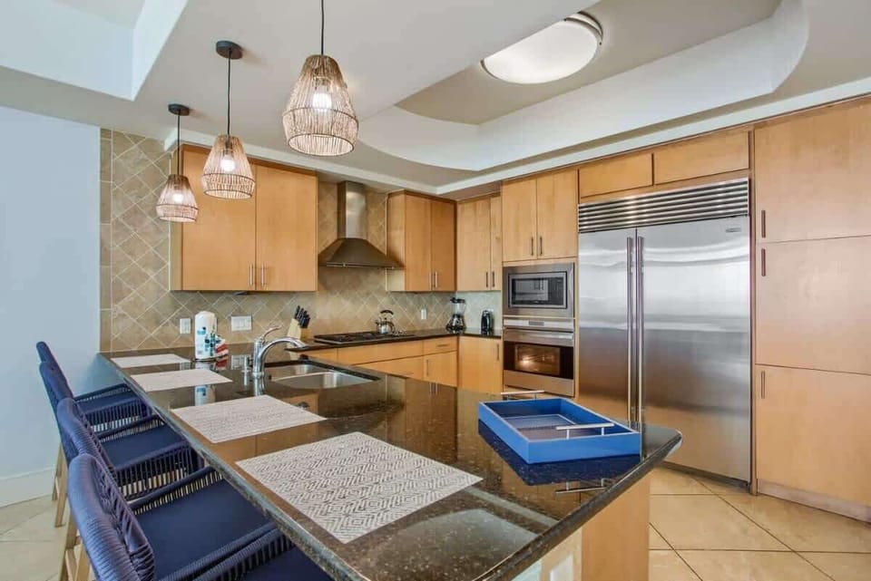 This modern kitchen features sleek granite countertops, warm wood cabinetry, and high-end stainless steel appliances. Perfect for cooking, entertaining, and making lasting memories!