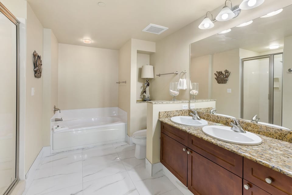 Unwind in your spacious master bathroom featuring dual vanities, granite countertops, and a relaxing soaking tub for luxurious evenings.