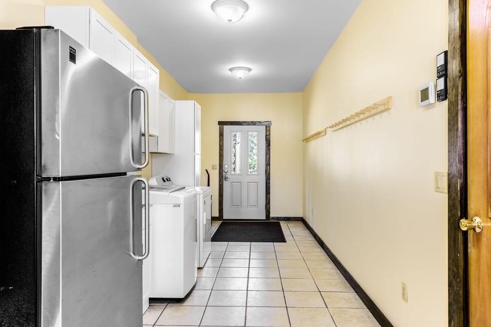 Entryway with washer, dryer, sink, and extra full fridge.