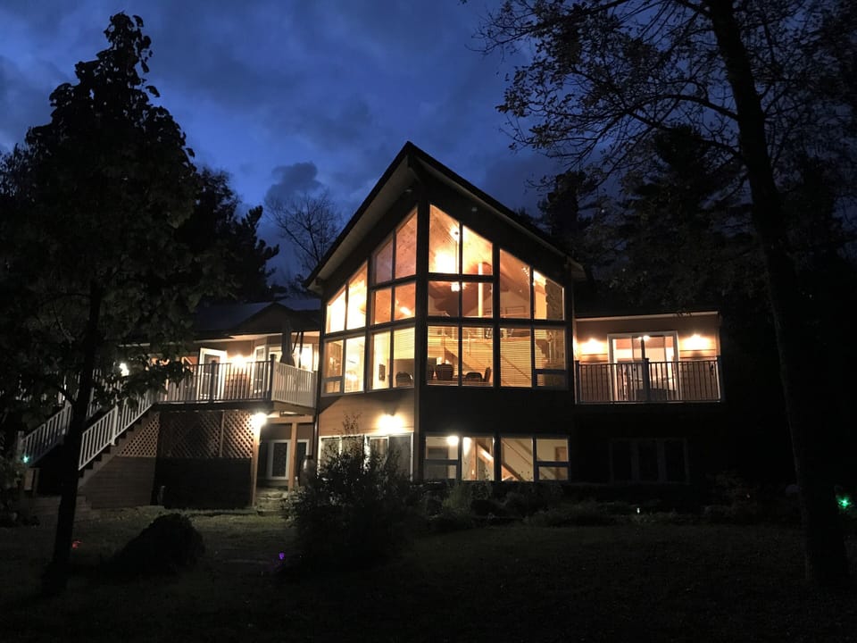 Cottage back at night with lights on